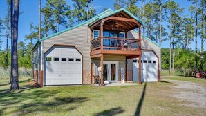 Une maison à deux étages avec un balcon, un garage et une véranda.