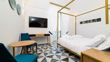 Una habitación de hotel moderna con una cama, un escritorio, una silla, un televisor y un suelo estampado.