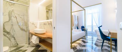 A modern bathroom with a glass shower, marble flooring, and a wooden vanity.