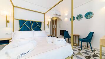 Une chambre d’hôtel avec un lit, deux chaises, un bureau et des assiettes décoratives accrochées au mur.