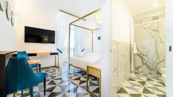 Een moderne hotelkamer met een bed, een bureau met stoel, een televisie en een douche.
