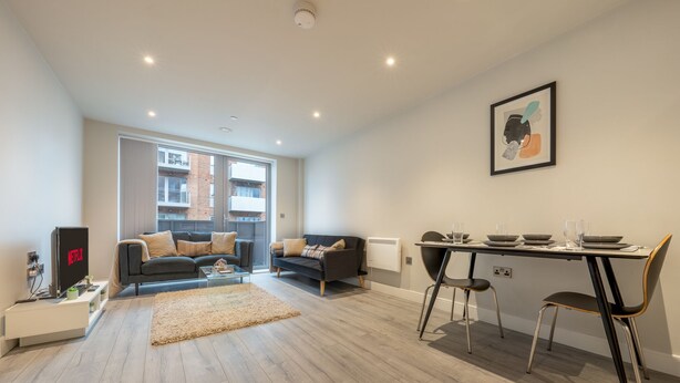 Una sala de estar moderna con un sofá, una mesa de centro y una mesa de comedor con sillas.