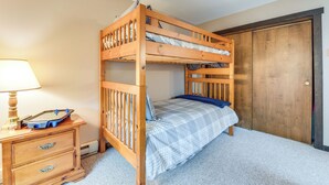A bunk bed with a wooden frame, a bedside table with a lamp, and a dresser with drawers. - Community Beach Access: Lake Harmony Townhome (Lake Harmony)