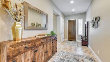 A hallway with a wooden cabinet, a mirror, and a decorative vase.