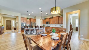 A spacious kitchen with wooden cabinets, a dining table set for six, and a large island. - Home w/ Hot Tub & Outdoor Space in Queen Creek! (Queen Creek)