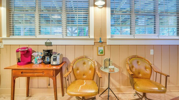 A room with two leather chairs, a wooden table with a coffee maker, and a small table with a lamp. - Inglis Studio Home w/ Covered Patio & Grill! (Inglis)