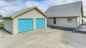 A two-story building with a garage and a covered porch.