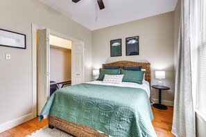 A bedroom with a bed, a bedside table, a lamp, and a door leading to another room. - Lakefront Oscar Home w/ Game Room + Boat Dock! (Oscar)