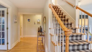 A staircase with wooden handrails and checkered carpet steps. - Expansive Group Getaway < 1 Mi to Dtwn Falmouth! (Falmouth)