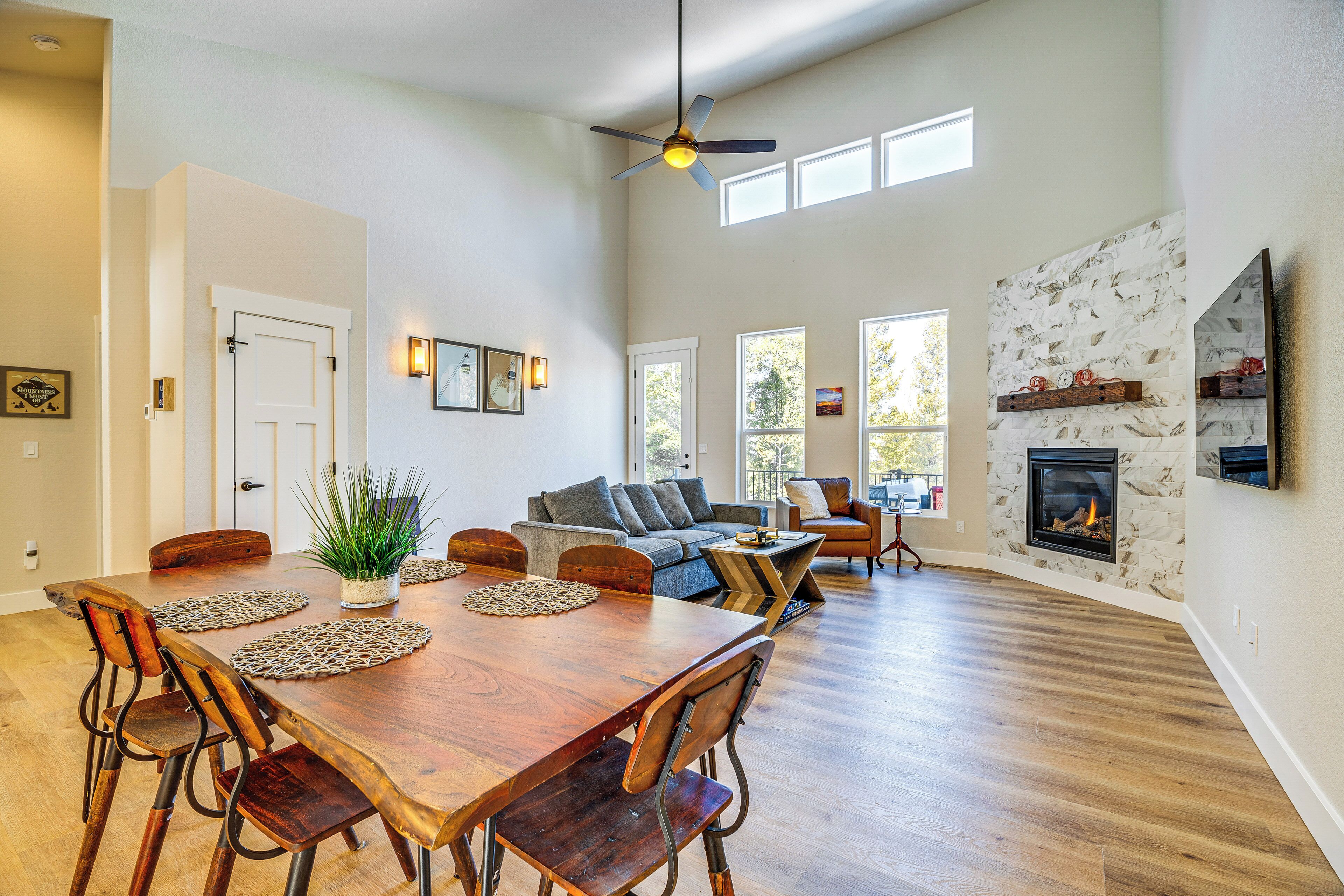 A spacious living area with a dining table, sofas, and a fireplace.