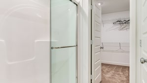 A room with a glass door, white walls, a clothes rack, and a carpeted floor. - Quiet Avon Home - Near Indianapolis Speedway! (Avon)