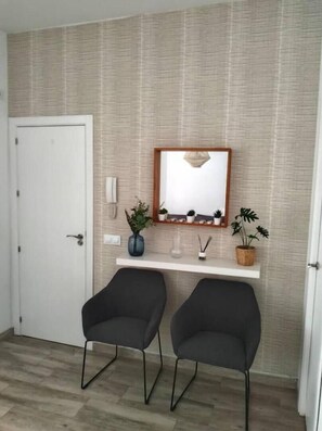 Relax in a serene space with a comfortable seating area, featuring a shelf with decorative accents and a potted plant.