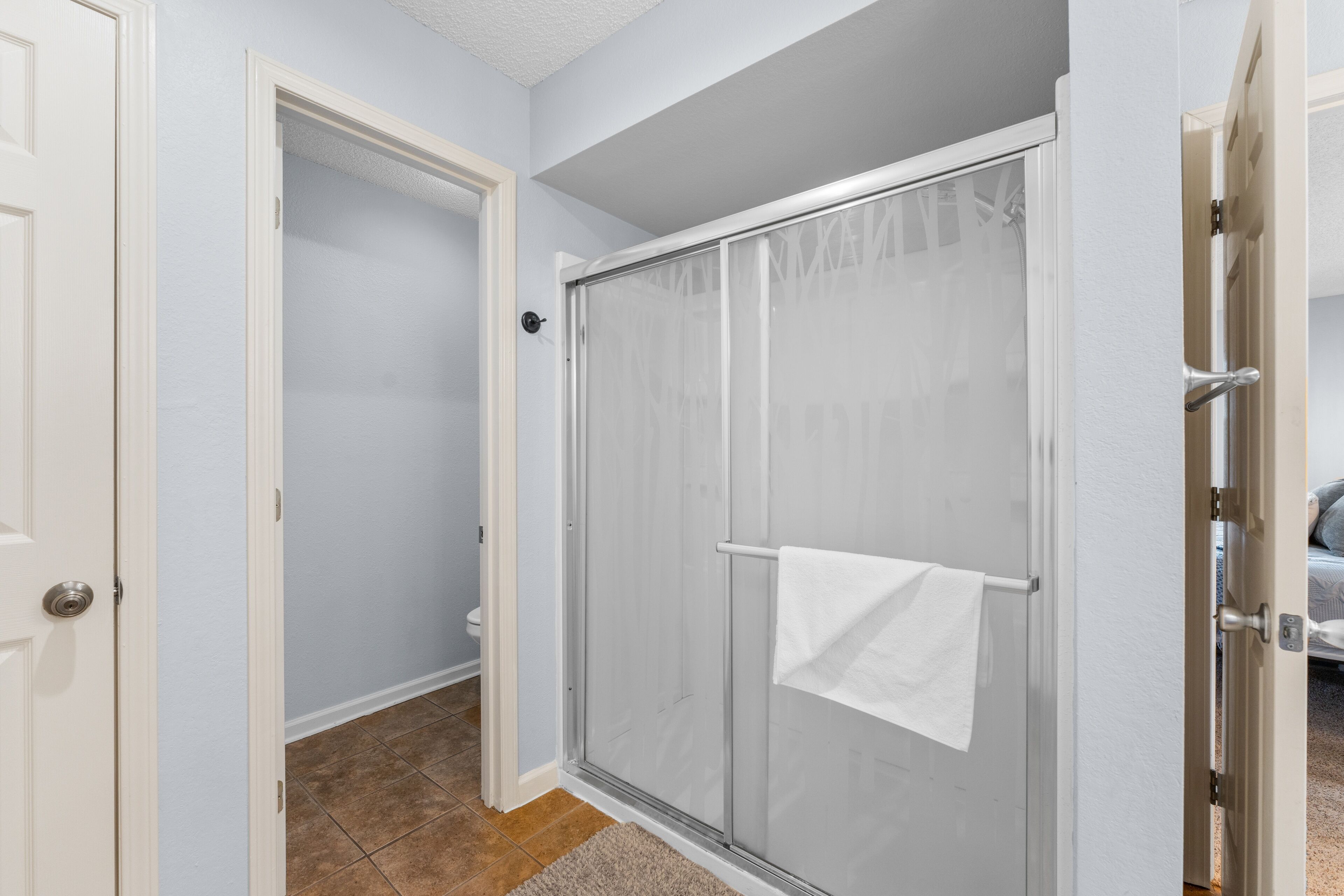 A bathroom with a shower, a toilet, and a sink.