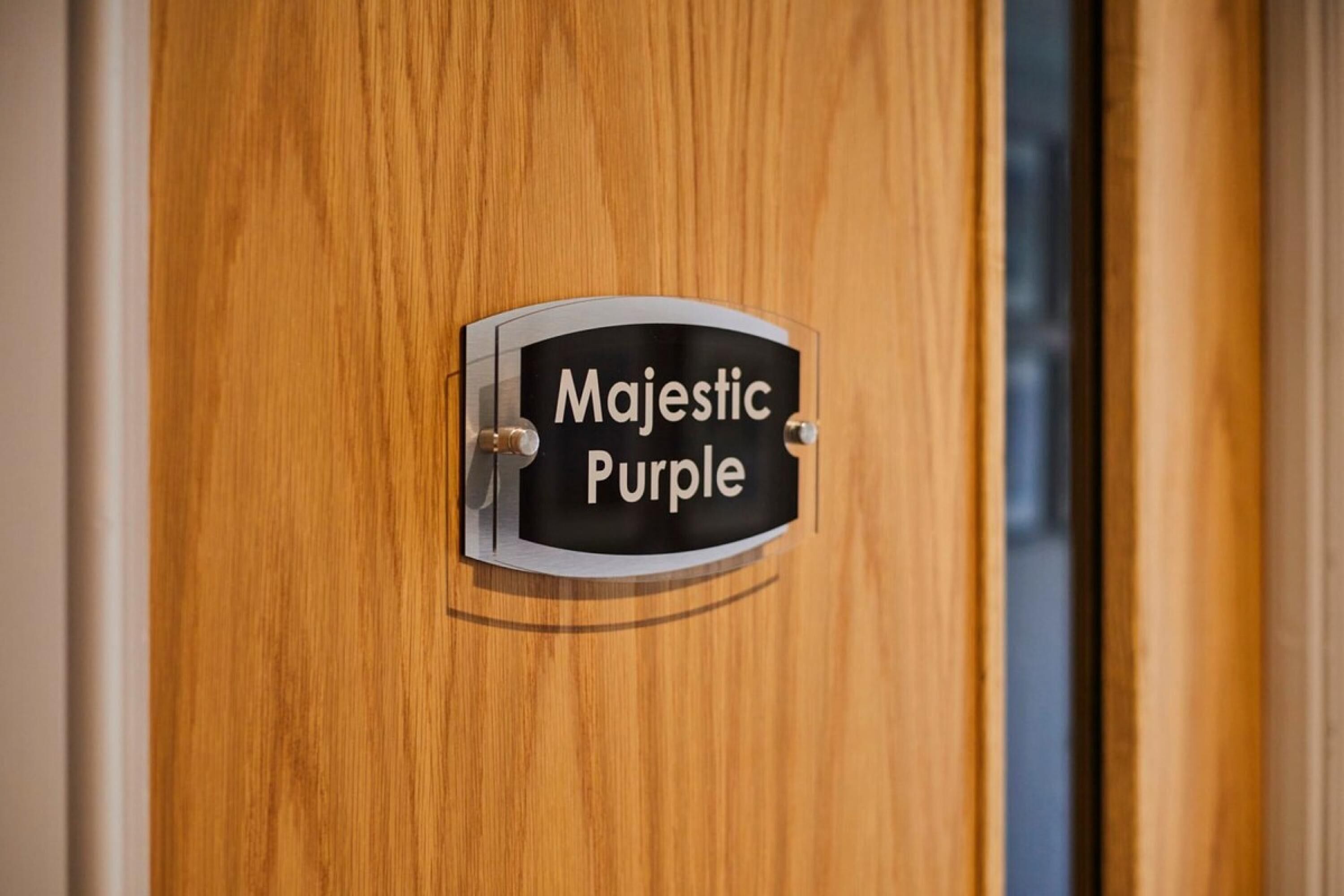 A wooden door with a sign that reads "Majestic Purple."