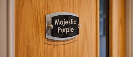 A wooden door with a sign that reads "Majestic Purple."