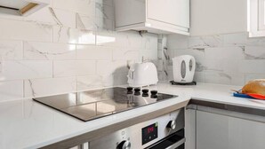 Une cuisine moderne équipée d’une cuisinière intégrée, d’une bouilloire et d’un grille-pain.