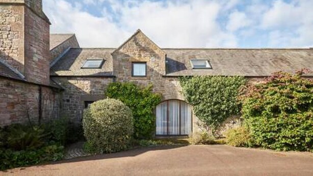 A stone building with a pitched roof, a small window, and a door. - Host Stay Grange Cottage (Belford)