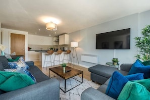 Relax in this stylish living space with a sofa, flat-screen TV, and dining area.