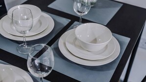 A table set with white plates, bowls, and wine glasses. - Host Apartments The Roscoe Nest (Liverpool)