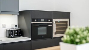 A modern kitchen with a built-in toaster, a double oven, and a microwave. - Host Apartments Wood St Nightlife Apt (Liverpool)