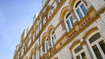 A multi-story building with classical architecture, featuring arched windows and ornate detailing.