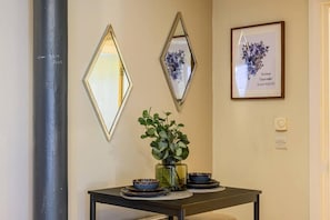 Enjoy meals in a beautifully set dining area with a vase, bowls, and framed artwork.