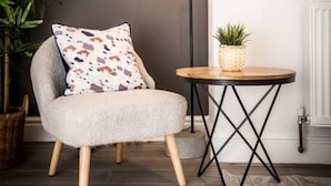 A modern room with a round mirror, a floor lamp, a small round table with a plant, and a chair with a patterned cushion. - Host Apartments Seel St Townhouse Apt I (Liverpool)
