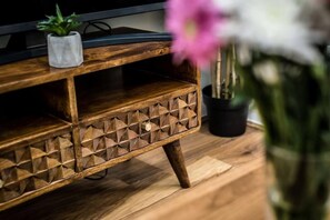 A wooden TV stand with geometric patterns and a small potted plant on top. - Host Stay The Georgian Quarters at Bedford (Liverpool)