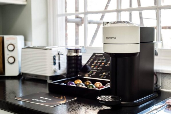 A coffee machine with a coffee pod box and a menu on the counter. - Host Stay Catharine Quarters I (Liverpool)