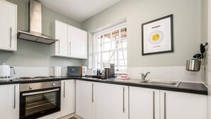 A modern kitchen with white cabinets, a built-in oven, a microwave, a coffee maker, and a large window. - Host Stay Catharine Quarters I (Liverpool)