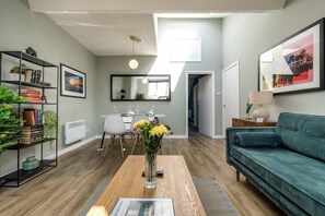 A modern living room with a sofa, coffee table, and a bookshelf. - Host Apartments The Georgian Quarters at Bedford (Liverpool)