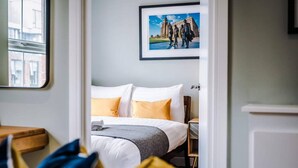 A hotel room with a bed, a framed picture on the wall, and a window with a view of buildings. - Host Apartments The Georgian Quarters at Bedford (Liverpool)