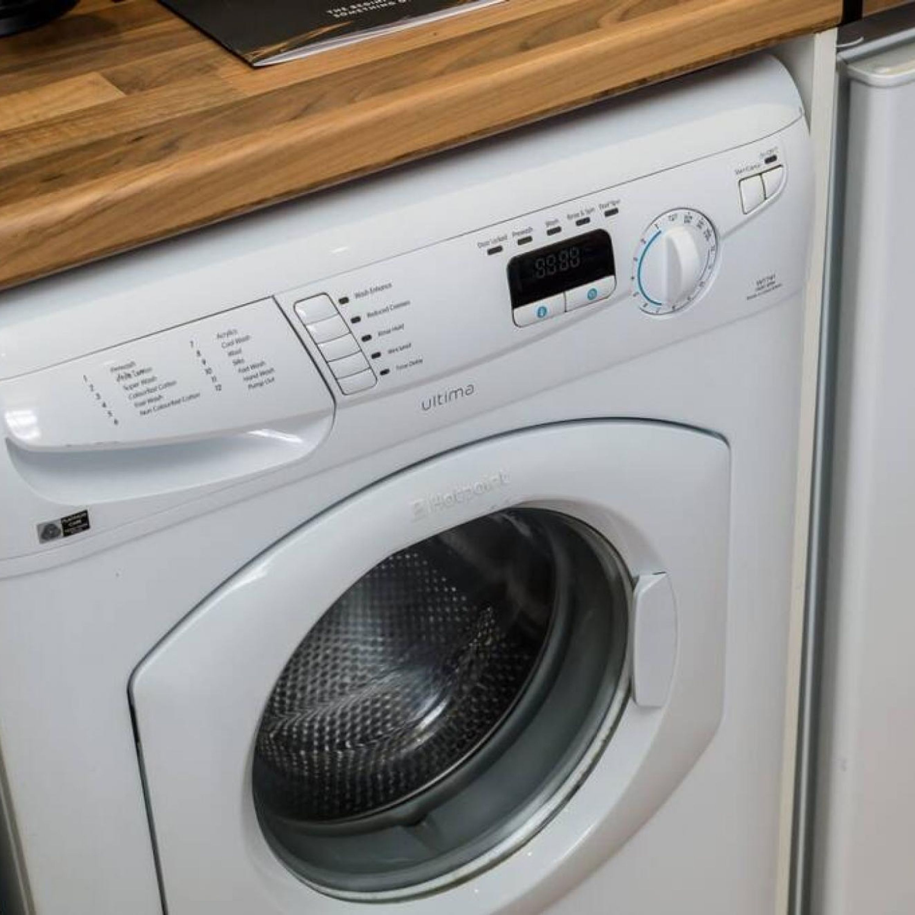 Vue de face d’un lave-linge moderne doté d’un écran numérique et d’un panneau de commande.
