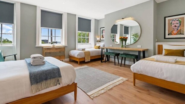 A modern hotel room with two beds, a desk, and a large mirror. - Host Apartments Upper Duke Street Apartment (Liverpool)
