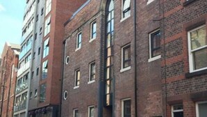 A row of brick buildings with multiple windows and balconies.