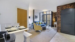 A modern living room with a dining area, a sofa, and a fireplace.