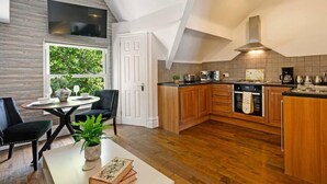 Une cuisine moderne avec des meubles en bois, un îlot central et un coin repas comprenant une table et des chaises.