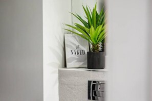 A bathroom with a white towel, a potted plant, and a towel rack. - Host Apartments Halifax House II (Liverpool)