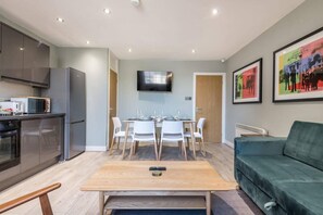 Relax in a stylish living area with a green sofa and dining table, perfect for meals and entertainment.