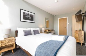 Relax in a serene space with a large bed, flat-screen TV, and a stylish nightstand.