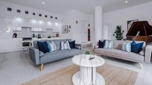Een moderne woonkamer met twee banken, een salontafel en een piano.