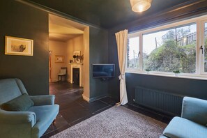A living room with two sofas, a TV, and a window with curtains. - Host Stay Prospect Cottage (Ulverston)