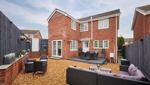 A brick house with a patio area, outdoor furniture, and a small garden. - Host Stay Violet s View (Whitby)