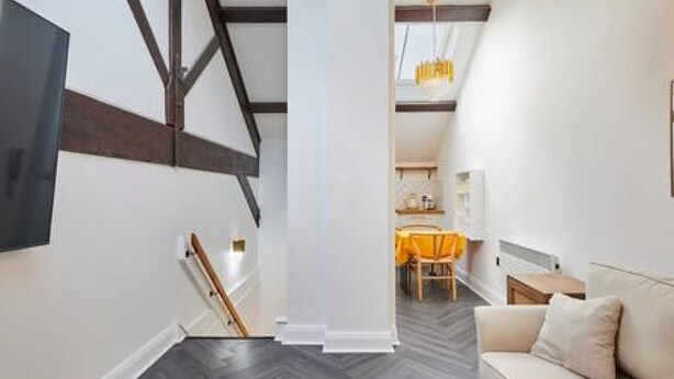 A modern interior with a staircase, a sofa, and a dining area. - Host Stay Queen Square Hideaway (Liverpool)