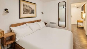 A bedroom with a large bed, a wooden headboard, a bedside table, a mirror, and a framed picture on the wall. - Host Stay Queen Square Hideaway (Liverpool)
