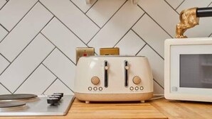 A kitchen with a white tiled backsplash, a wooden countertop, a white toaster, and a white microwave. - Host Stay Queen Square Hideaway (Liverpool)