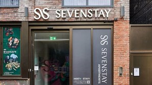 Un bâtiment en briques doté d’une grande entrée en verre et sur lequel on peut lire en lettres bien visibles l’inscription « SS SEVENSTAY ».