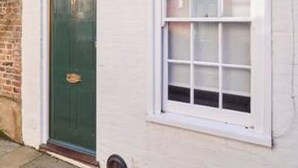 A white building with a green door and a window with white frames. - Host Stay St Radigunds House (Canterbury)