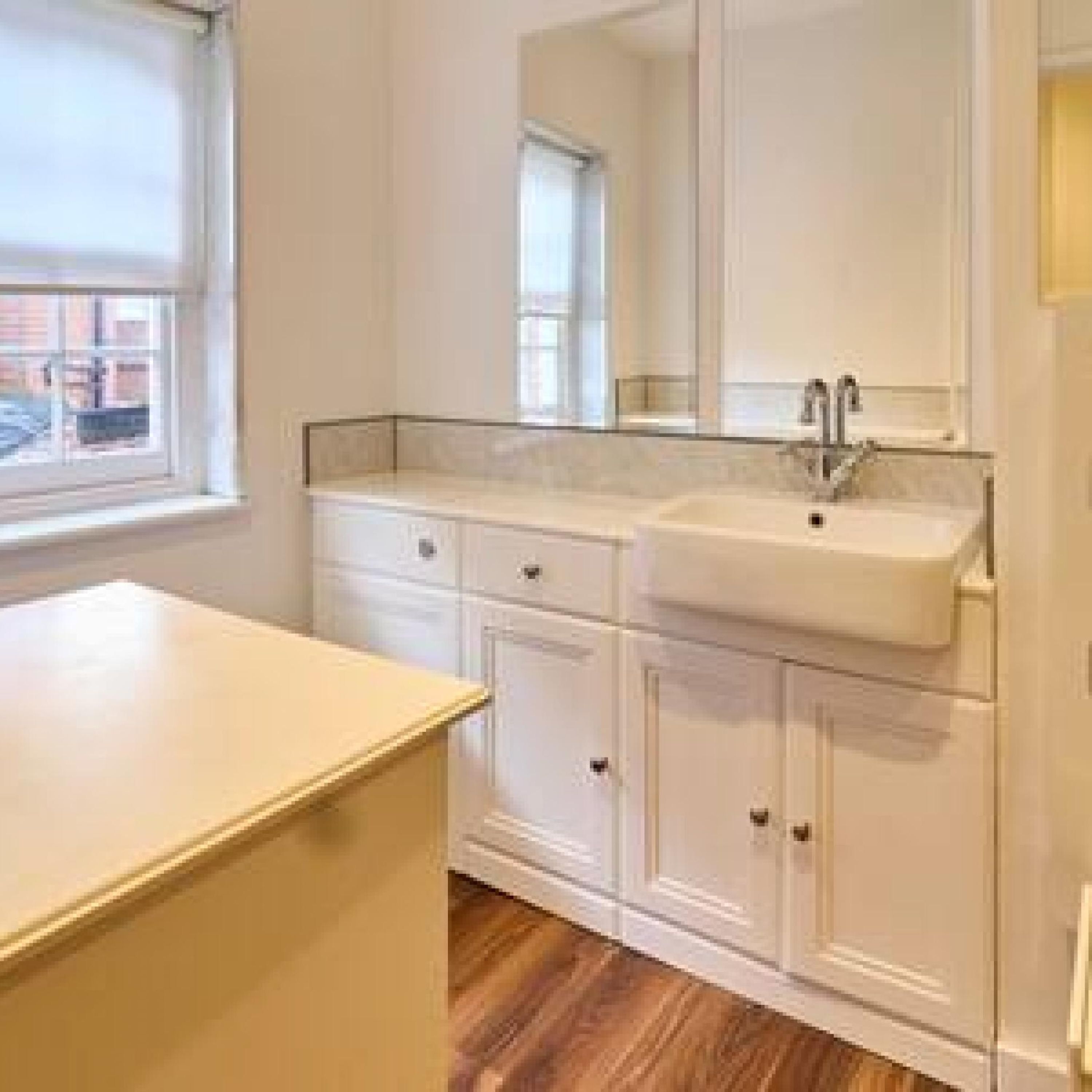 A bathroom with a sink, mirror, and cabinets.