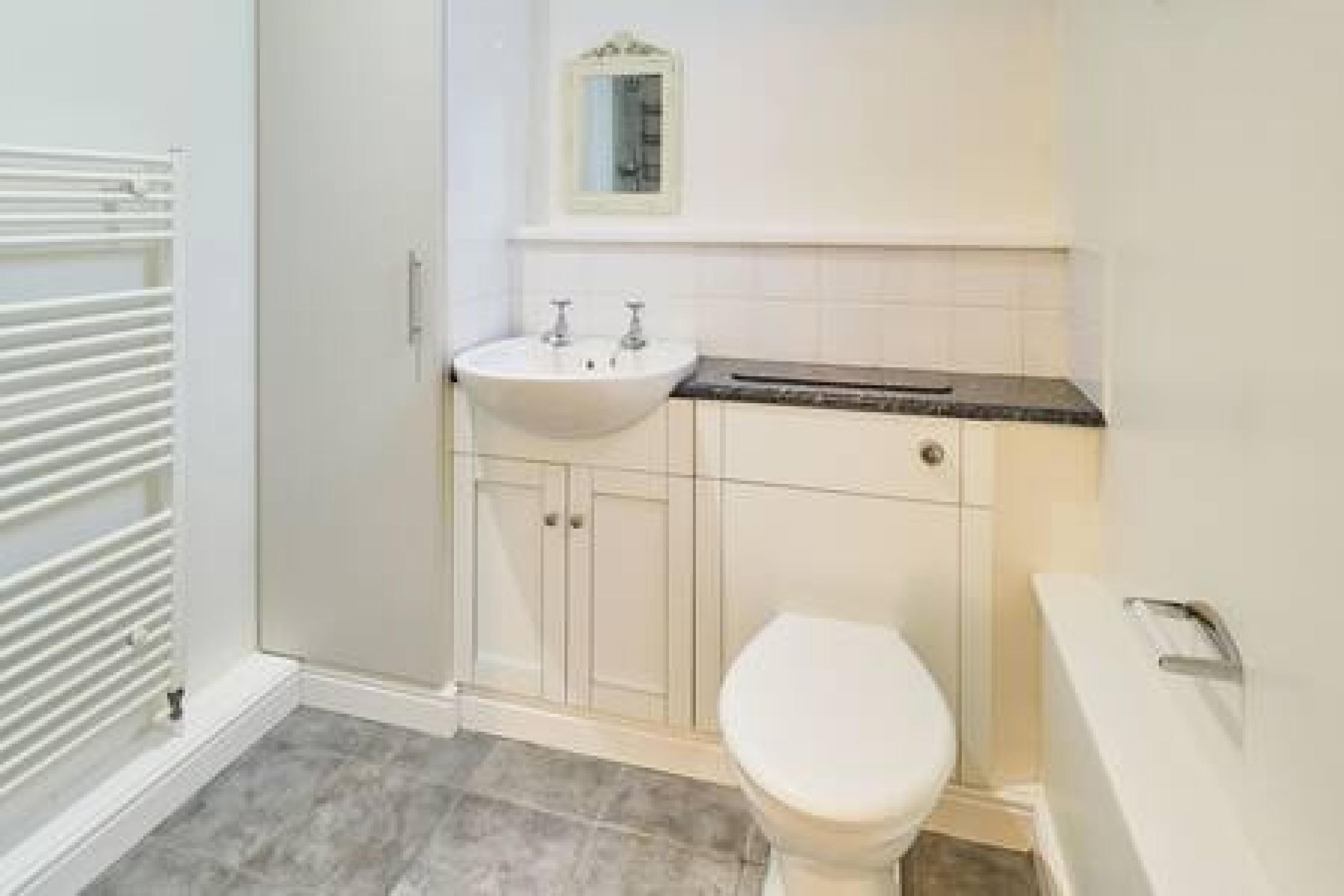Een badkamer met een toilet, een wastafel en een spiegel.